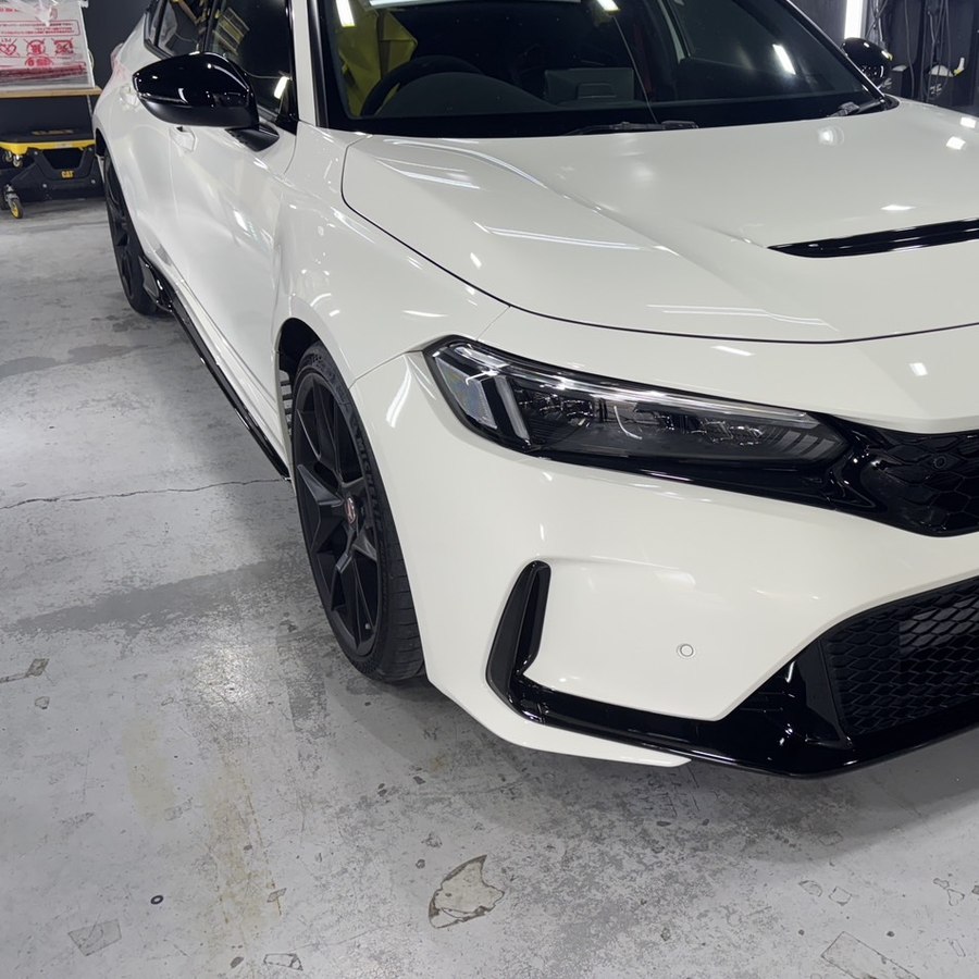 名古屋スタートラストの屋内ブースで施工を終えた白いホンダ・シビック。ボンネットに照明が映り込んでいる